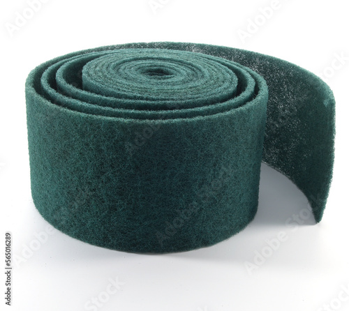 Estropajo verde en rollo sobre fondo blanco. Green scouring pad on a roll on a white background.