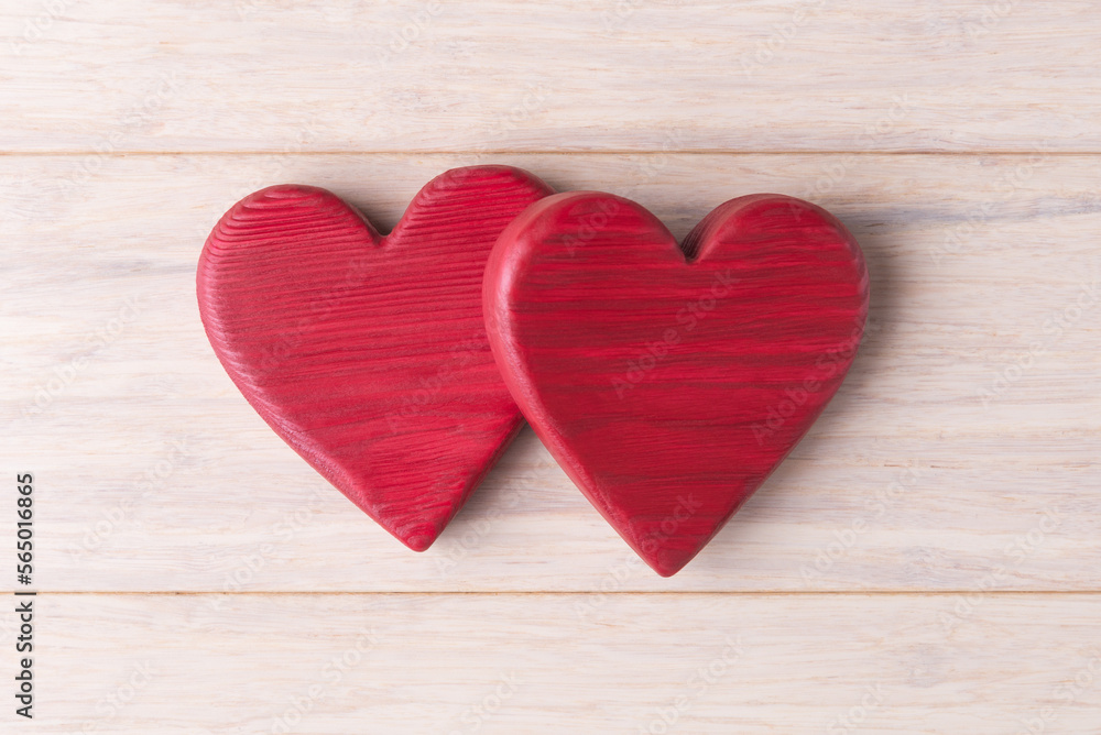 Two red wooden Valentines hearts on light background. Valentine’s day concept Two red wooden Valentines hearts on light background. Valentine’s day concept