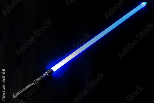 Colorful blue purple glowing laser sword with shiny silver metal grip against black background. Photo taken January 26th, 2023, Zurich, Switzerland.