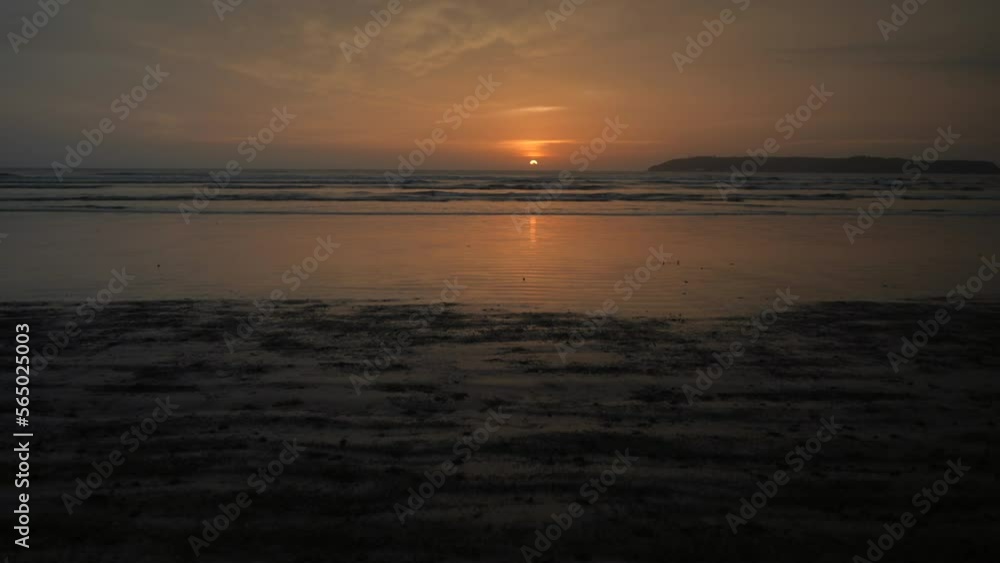 Landscape view of a young woman silhouette running on a sandy beach by the ocean, at sunrise Landscape view of a young woman silhouette running on a sandy beach by the ocean, at sunrise