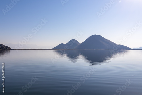 Scenic view of Lake Skadar National Park in autumn near Virpazar, Bar, Montenegro, Balkans, Europe. Hills striking out with Dinaric Alps in back, Albania. Stunning landscape water reflection in nature