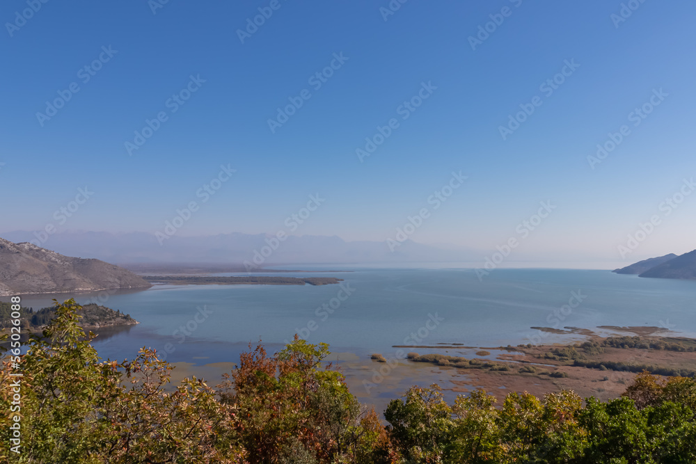 Panoramic view of Lake Skadar National Park in autumn near tourist village Virpazar, Bar, Montenegro, Balkans, Europe. Travel destination in Dinaric Alps near Albania. Stunning landscape and nature Panoramic view of Lake Skadar National Park in autumn near tourist village Virpazar, Bar, Montenegro, Balkans, Europe. Travel destination in Dinaric Alps near Albania. Stunning landscape and nature