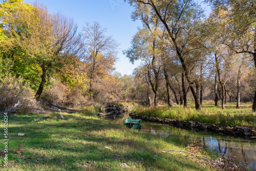 Green boat floating on the Seljani stream in idyllic village Poseljani in Lake Skadar National Park, Bar, Montenegro, Balkans, Europe. Hiking trail to peaceful authentic local area in Dinaric Alps photo