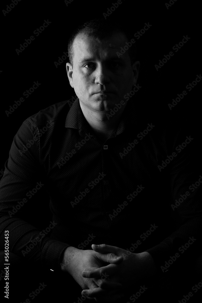 Black and white photo of a man in a shirt on a black background Black and white photo of a man in a shirt on a black background