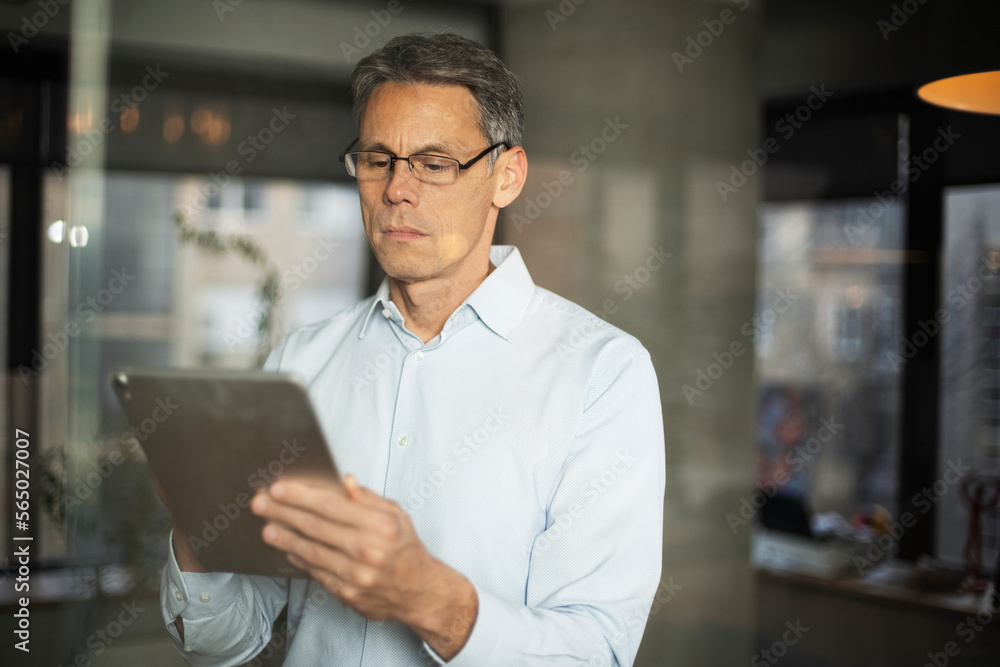 Portrait of successful businessman in office. Man writing on the glass board in office Portrait of successful businessman in office. Man writing on the glass board in office