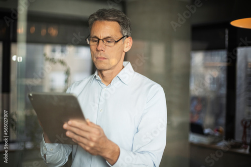 Portrait of successful businessman in office. Man writing on the glass board in office