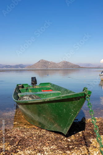 Colourful fishermen boat at lakeshore with scenic of Lake Skadar National Park in autumn near Godinje, Bar, Montenegro, Balkans, Europe. Stunning travel destination in Dinaric Alps near Albania