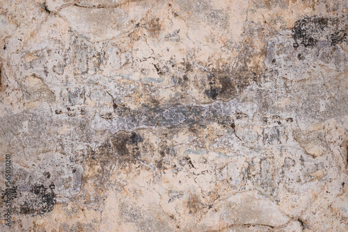 Damaged dirty plaster wall with rough texture and stain