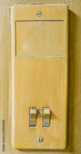 Yellow old light switch on the wall close-up.