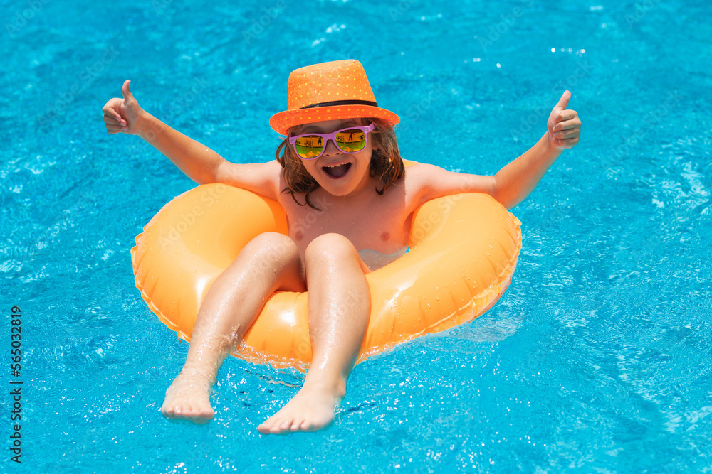 Kid in sunglasses in pool in summer day. Children playing in swimming pool. Summer holidays and vacation concept.