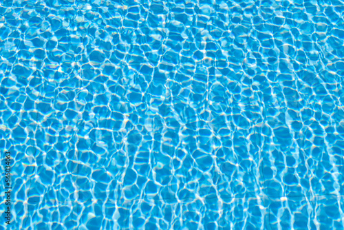 Texture of blue vivid swimming pool, light going through water