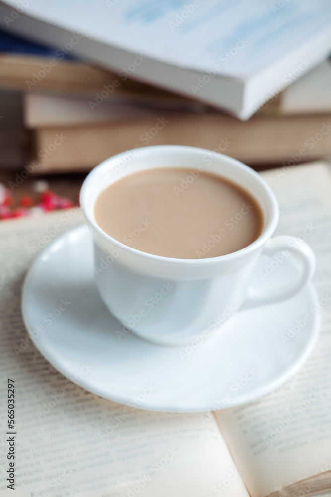 Coffee in a white cup stands on a book, close-up Coffee in a white cup stands on a book, close-up