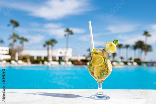 Mohito fresh cold cocktail on the marble table with eco paper straw in the all inclusive hotel near the swimming pool