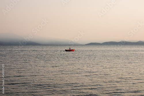 Lone fishermen at work under the Smoke filled skies of Volos, greece