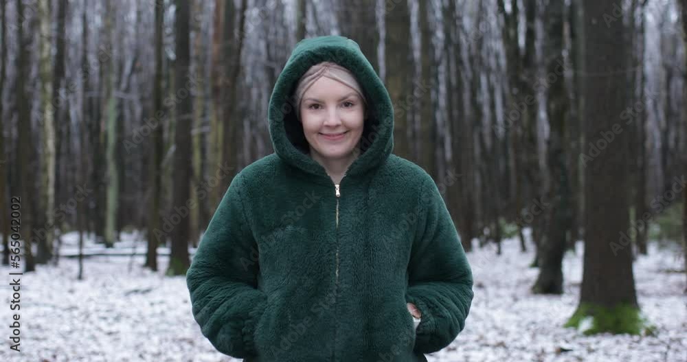Happy middle aged woman in winter forest, go forward to camera on wet snow path in park. Smiling person walk outdoors. Happy middle aged woman in winter forest, go forward to camera on wet snow path in park. Smiling person walk outdoors.