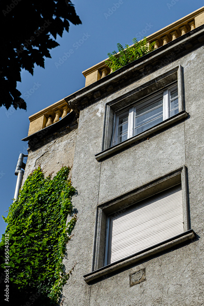 an old type house with windows and plants on it, under a blue sky on a sunny day in budapest