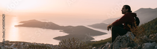 Fotografi A young man meets on a mountain by the sea meets the sunset.