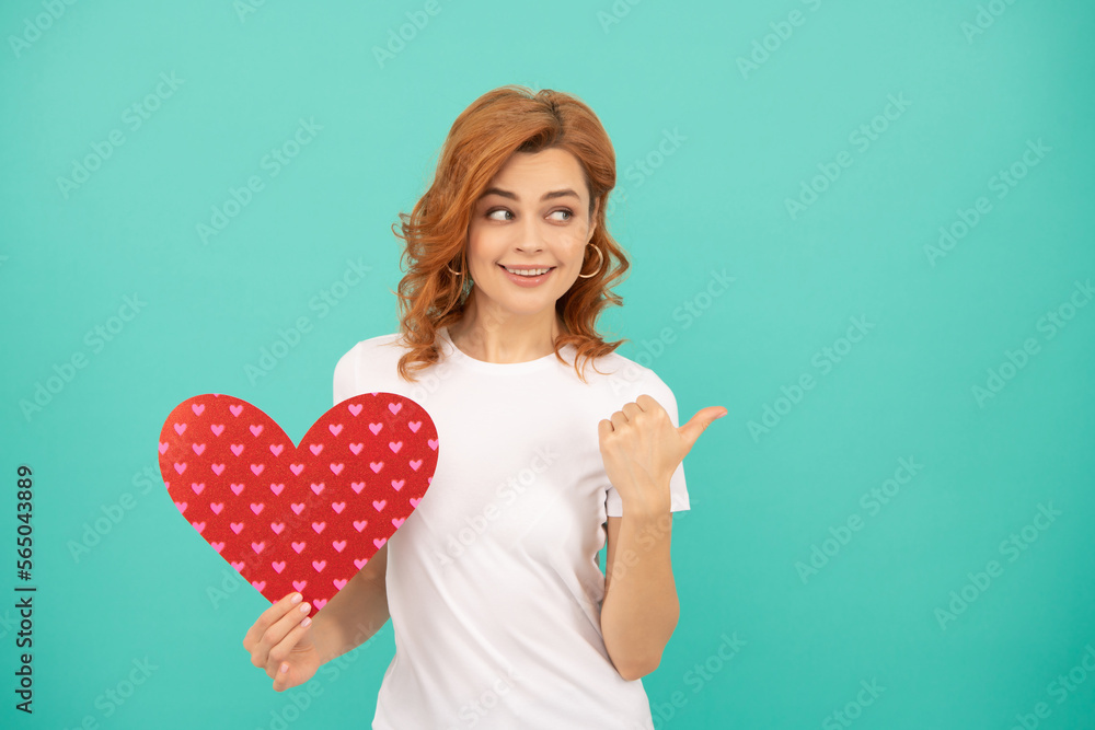 positive young woman with red heart on blue background. thumb up positive young woman with red heart on blue background. thumb up