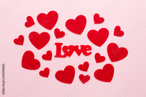 Felt word love with hearts on color background, top view