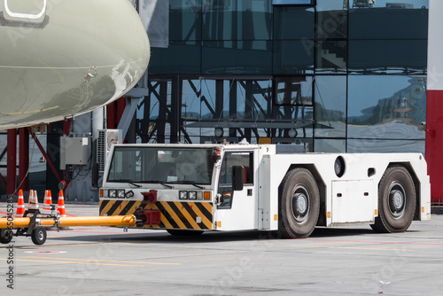 Tow truck pushes the passenger jet plane