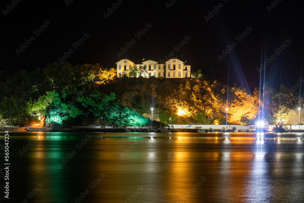 Old buildings lit at night across the Water in Thassos.