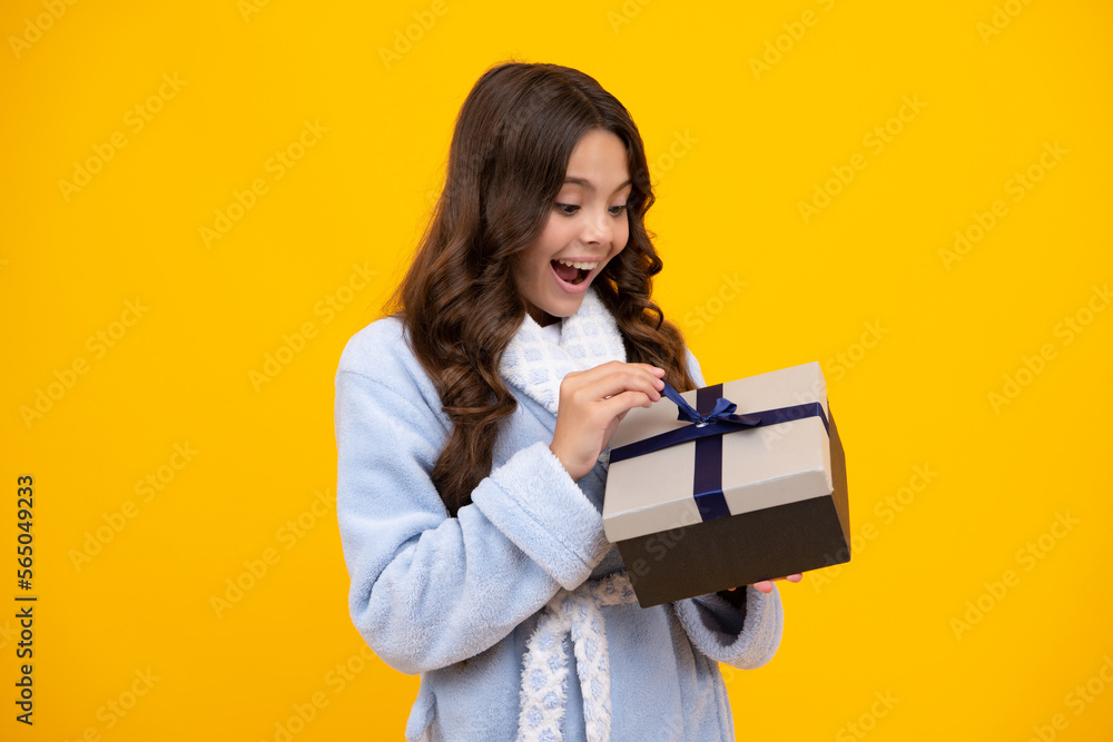 Amazed teen girl. Child with gift present box on isolated studio background. Gifting for kids birthday. Excited expression, cheerful and glad. Amazed teen girl. Child with gift present box on isolated studio background. Gifting for kids birthday. Excited expression, cheerful and glad.