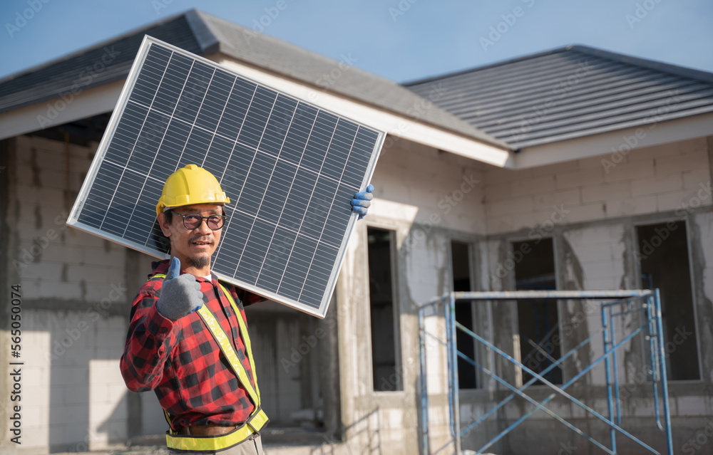 Engineer carrying solar panels Preparing to install on the roof of the house technician man with safety and protective gear installs solar panels on a roof. technician moving a solar panel Engineer carrying solar panels Preparing to install on the roof of the house technician man with safety and protective gear installs solar panels on a roof. technician moving a solar panel