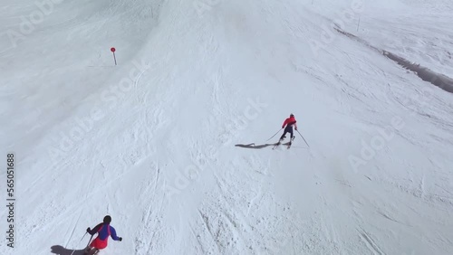 Drone view of skiers going down a slope in the Pyrenees, Spain, 
learning to ski