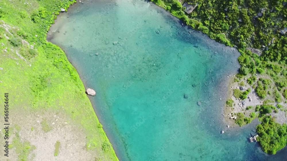 Aerial top down flight over amazing small lake. Cloudy sky reflected in clear turquoise water of pond surrounded by trees and plants. Untouched nature from above on summer day.Drone Aerial top down flight over amazing small lake. Cloudy sky reflected in clear turquoise water of pond surrounded by trees and plants. Untouched nature from above on summer day.Drone