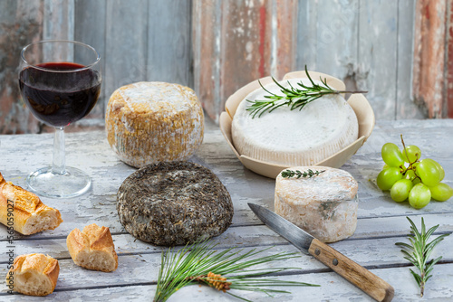 Corsican traditional varity of goat and sheep cheese and glass of red vine on wood background photo