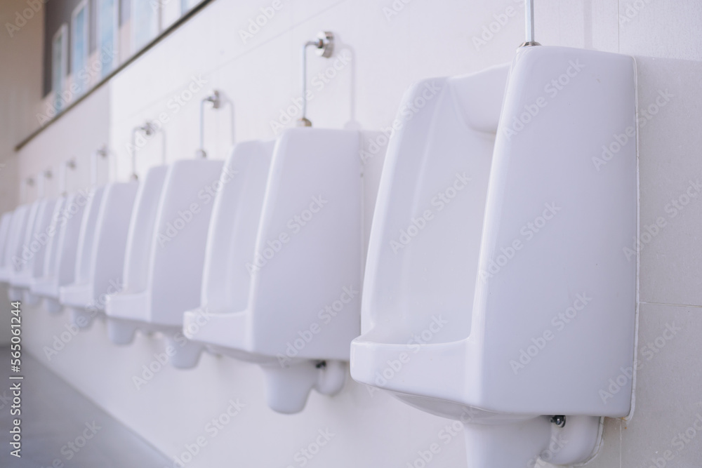 Row of clean and hygiene white urinals in men's public outdoor restroom