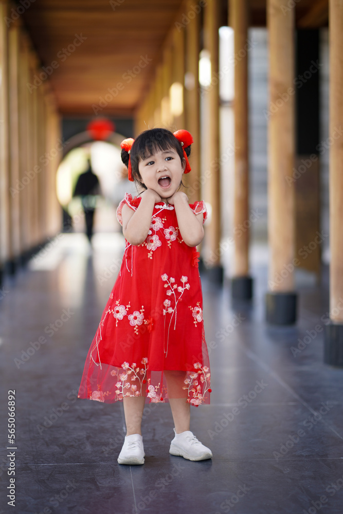 Happy asian little girl in Chinese traditional costume posting and smiling in the pavilion. Happy asian little girl in Chinese traditional costume posting and smiling in the pavilion.