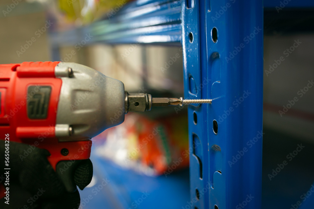 Mechanic holding electric cordless screwdriver drill in the factory. Working with the screw. Mechanic holding electric cordless screwdriver drill in the factory. Working with the screw.
