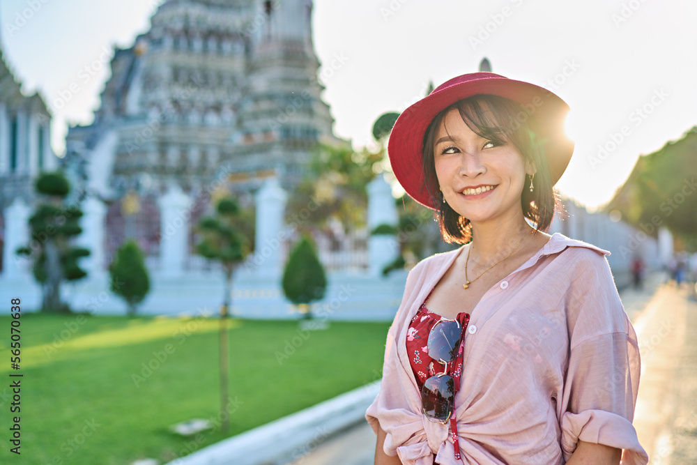 happy thai woman at war arun temple in background located in bangkok thailand