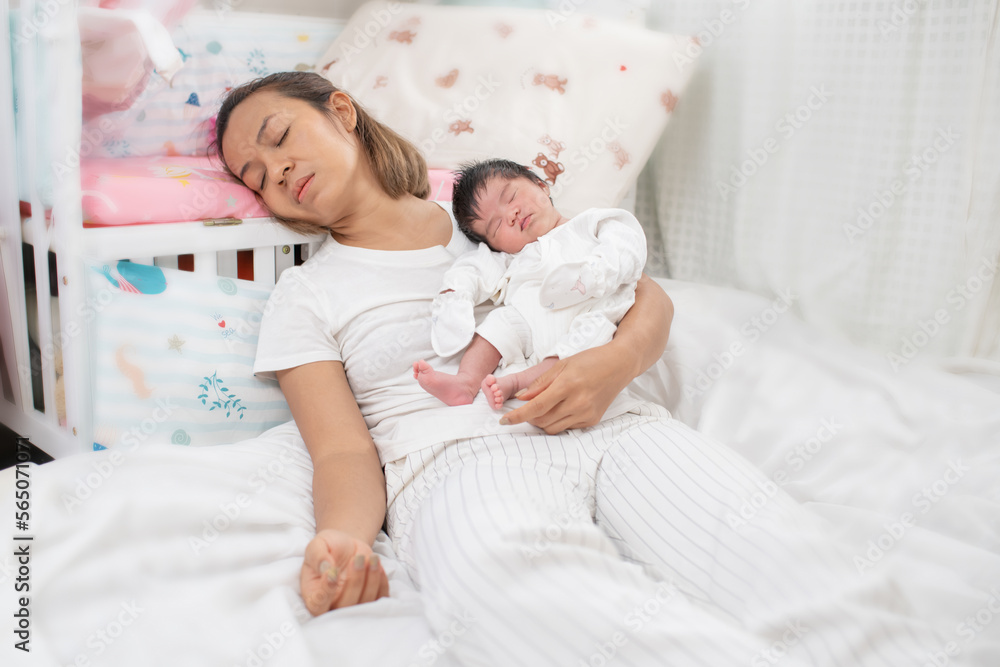 tired mother suffering from experiencing postnatal depression sitting on bed near children's cot. mother sleeping embracing to her asleep baby daughter sitting at home. single mom motherhood stressful tired mother suffering from experiencing postnatal depression sitting on bed near children's cot. mother sleeping embracing to her asleep baby daughter sitting at home. single mom motherhood stressful