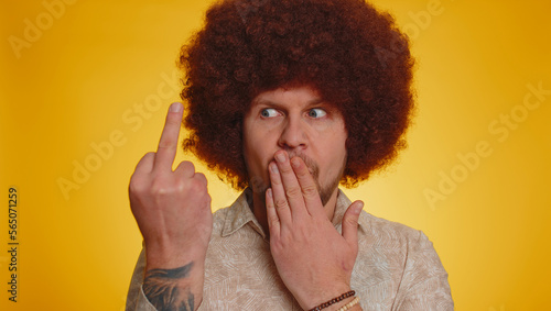 Aggressive crazy hooligan man showing around his middle fingers  demonstrating protest with impolite rude gesture of disrespect  rejecting communication. Hipster guy with lush afro hairstyle coiffure
