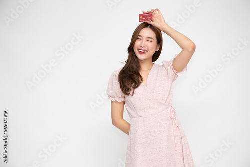 Young beautiful Asian woman smiling, showing, presenting credit card for making payment or paying online business isolated on white background