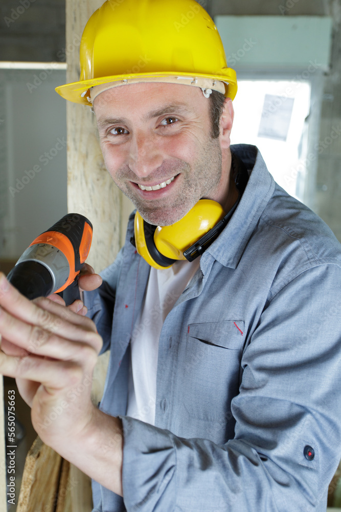 smiling craftsman with electric drill in spacious workshop smiling craftsman with electric drill in spacious workshop