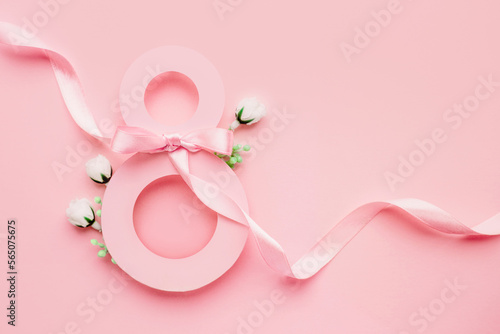 March 8. Paper number eight decorated with spring flowers on a pink background