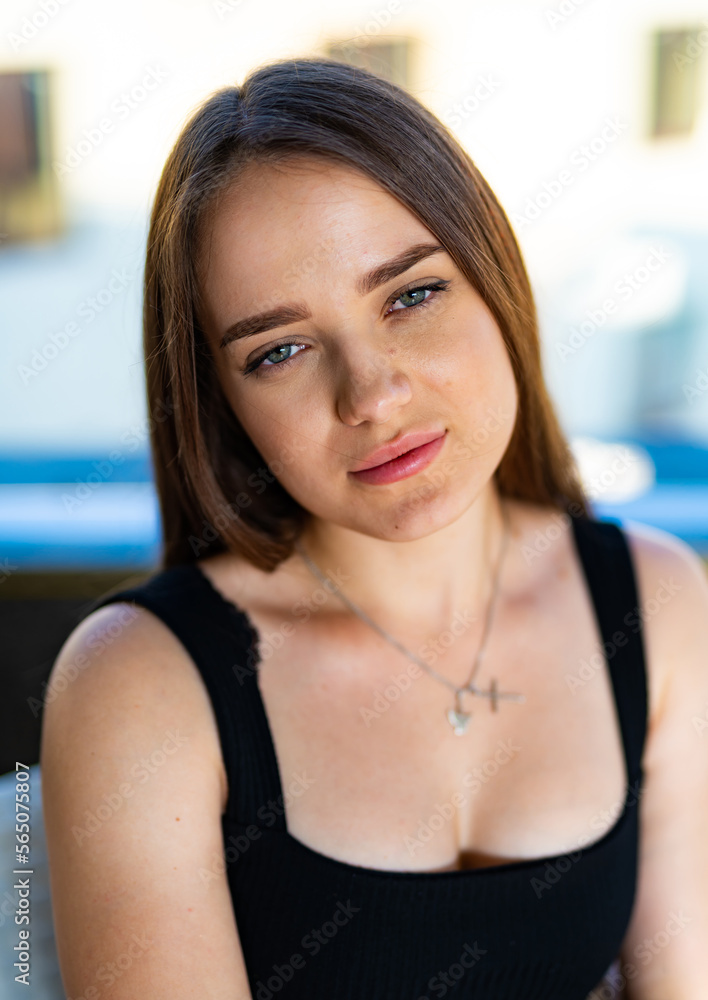 Sunny outdoor lifestyle lady. Portrait of pretty young woman relaxing.