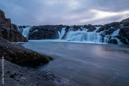 Majestic summer sunrise on Bruarfoss Waterfall. The  Iceland   s Bluest Waterfall.  Blue water flows over stones. Midnight sun of Iceland. Visit Iceland. Beauty world.