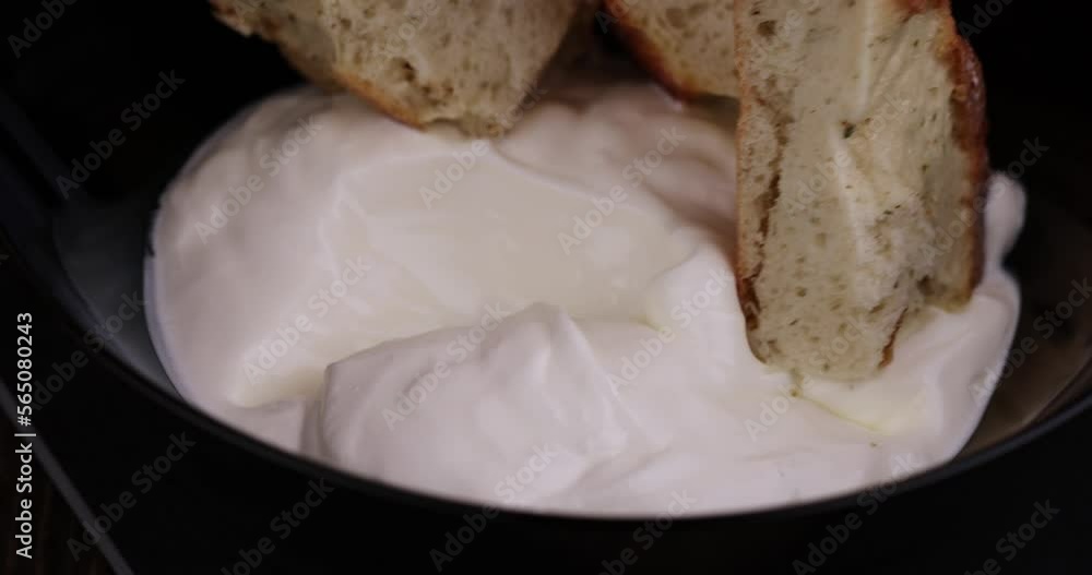 oriental flatbread made of wheat flour with sour cream, parts of oriental fresh flatbread on the table and sour cream from milk oriental flatbread made of wheat flour with sour cream, parts of oriental fresh flatbread on the table and sour cream from milk