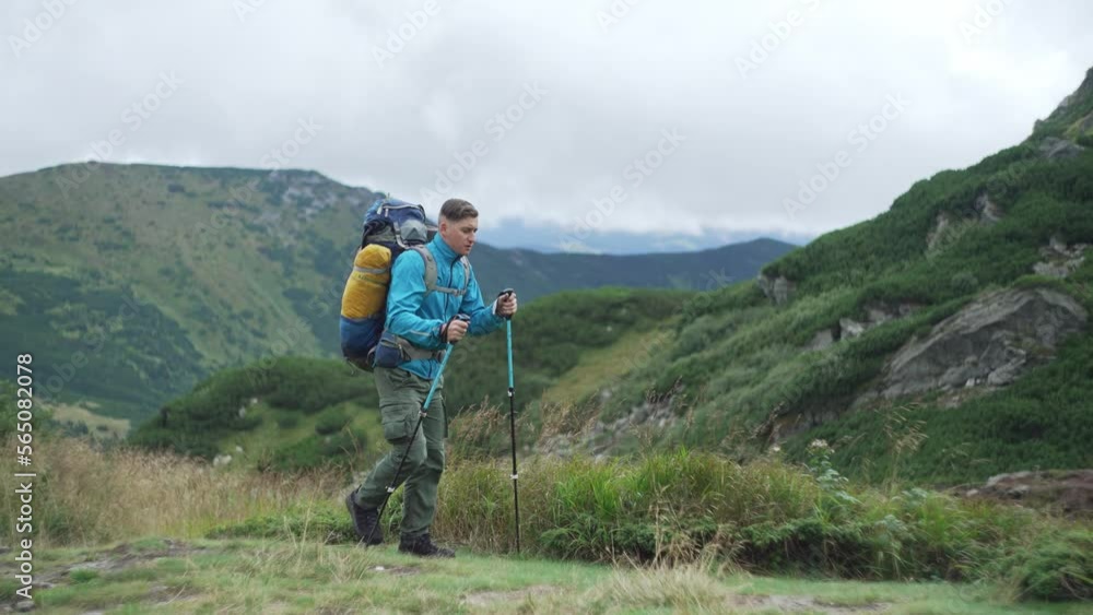 A tourist with a backpack is hiking in the mountains. The traveler sets out to conquer the top of the mountain in a beautiful landscape. Concept: freedom, happiness, fatigue. High quality 4k footage A tourist with a backpack is hiking in the mountains. The traveler sets out to conquer the top of the mountain in a beautiful landscape. Concept: freedom, happiness, fatigue. High quality 4k footage
