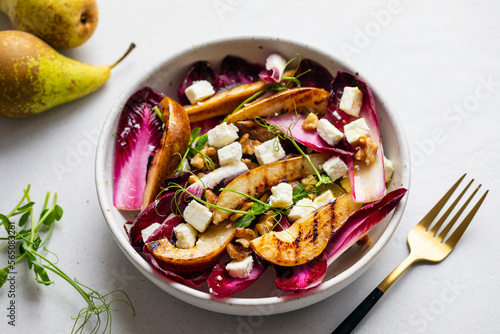 Roasted pear and chicory salad with walnuts and feta cheese photo