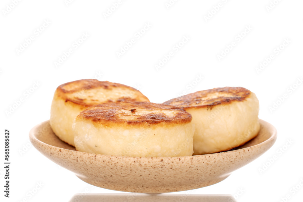 Three homemade cheese pancakes on a ceramic saucer, macro, isolated on a white background. Three homemade cheese pancakes on a ceramic saucer, macro, isolated on a white background.