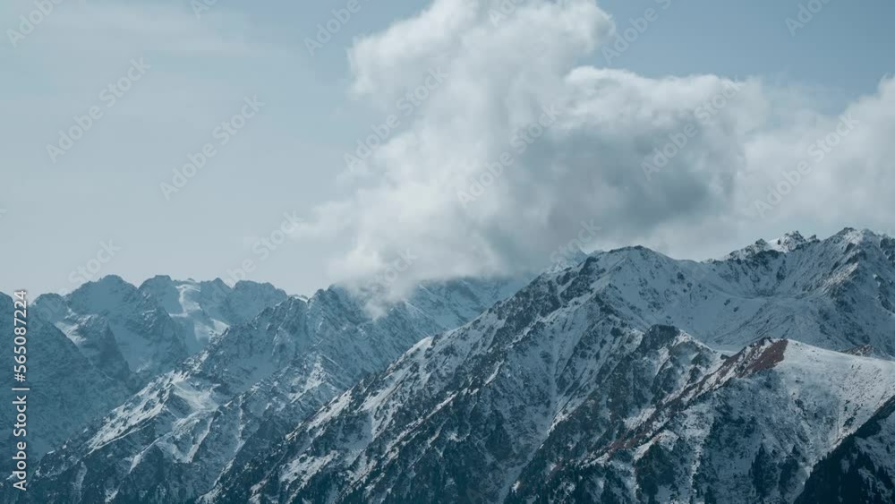 Clouds forming over rocky and snowy mountains. Scenic mountains of Kyrgyzstan. Beautiful timelapse with slow camera zoom Clouds forming over rocky and snowy mountains. Scenic mountains of Kyrgyzstan. Beautiful timelapse with slow camera zoom
