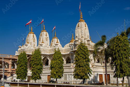 Beautiful Swaminarayan Temple in white marble stone with beautiful carving and flags flying in the wind in Bhuj in Gujarat