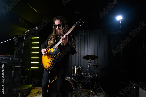 Guitarist man plays an electric guitar Close-up at studio