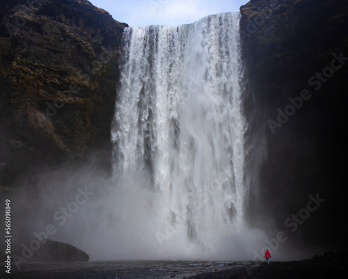 Fototapeta Naklejka Na Ścianę i Meble -  Fearless strong woman faces powerful waterfall; concept of strong and invincible woman, female strength, dangerous waterfall in iceland