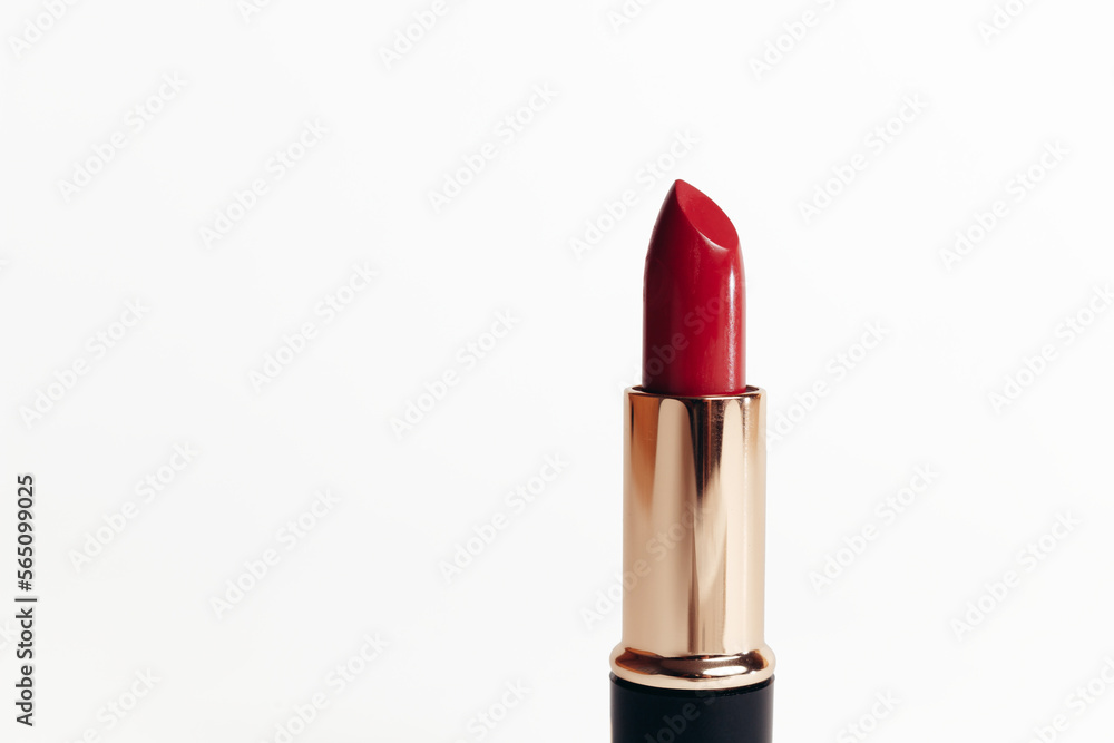 Isolated new red lipstick without cap in a golden container on a white background, macro photo Isolated new red lipstick without cap in a golden container on a white background, macro photo